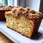 Close-up of a moist slice of Coffee Cake featuring a thick, buttery cinnamon streusel topping.