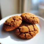 Three chewy Brown Sugar Cookies coated in sparkling sugar resting on a white plate.