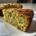 Close-up of a moist slice of Zucchini Cake showing shredded green zucchini baked into the crumb.