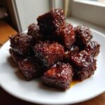 A pile of crispy, glazed tofu cubes coated in a rich, dark black pepper sauce.