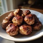 A pile of perfectly browned Air Fryer Meatballs with a crispy exterior, served on a white plate.
