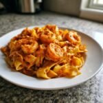 A close-up of Creamy Cajun Shrimp Pasta With Pappardelle served on a white plate.
