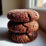 Three dark, chewy Irresistible Gingerbread Snaps stacked, coated heavily in sparkling granulated sugar.