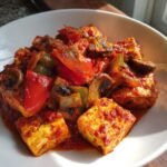 Close-up of Irresistible Tofu Cacciatore featuring seared tofu cubes in rich tomato sauce with mushrooms and bell peppers.