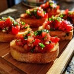 Close-up of several pieces of My Fave Easy Classic Bruschetta topped with fresh diced tomatoes and basil.