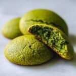 Close-up of Zesty Lime Matcha Cookies, showing one cookie broken in half revealing a soft, green interior.