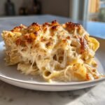 A close-up of a serving of Extra Cheesy Chicken Alfredo Bake Recipe Comfort Food Magic with a golden, bubbly top.