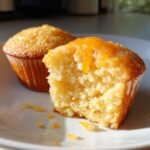 Close-up of an Irresistibly Fluffy Orange Cupcakes, showing the moist interior and orange glaze.