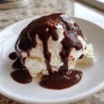 Scoop of vanilla ice cream generously covered in dripping Homemade Magic Shell chocolate sauce.