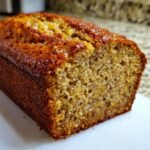 A close-up shot of a freshly baked loaf of Irresistible Brown Butter Banana Bread showing its moist crumb and golden-brown crust.