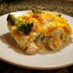 A close-up serving of the Irresistible Chicken Divan Recipe, showing chunks of chicken, broccoli, and melted cheddar cheese.