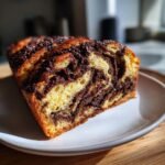 A close-up view of sliced Irresistible Chocolate Babka Recipe showing rich chocolate swirls in the golden dough.