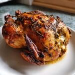A perfectly roasted whole chicken, glistening with herbs, ready for an Irresistible Christmas Chicken Recipe feast.