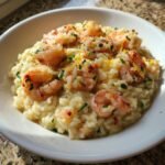 A creamy bowl of Irresistible Lemon Garlic Shrimp Risotto topped with plump shrimp and lemon zest.