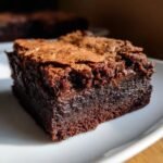 Close-up of a fudgy slice of Irresistible Nutella Brownies showing a crackly top and gooey center.