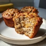Close-up of Irresistible Peanut Butter Banana Oatmeal Muffins, one broken open showing a creamy peanut butter center.