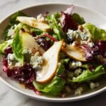 Close-up of an Irresistible Pear And Blue Cheese Salad featuring sliced pears, crumbled blue cheese, and mixed greens.