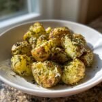 A white bowl filled with roasted, seasoned Irresistible Ranch Potatoes Recipe, garnished with herbs.