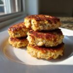 A stack of four perfectly cooked, golden-brown Irresistible Tuna Patties resting on a white plate.