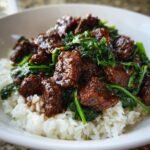 Close-up of Irresistible Slow Cooker Korean Beef served over white rice with wilted spinach.