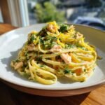 A creamy mound of Zesty Lemon Dill Salmon Pasta topped with fresh dill and lemon zest.