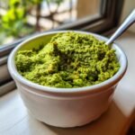 Close-up of thick, bright green 2 Minute Green Olive Dip texture in a small white ramekin with a spoon.