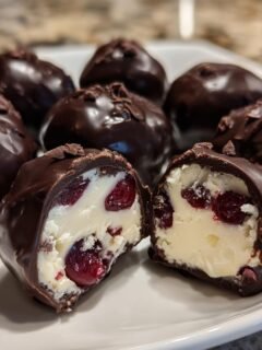 Close-up of Chocolate Covered Cherry Dessert Balls, one cut in half showing creamy filling and cherries.