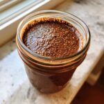 Close-up of Chocolate Protein Overnight Oats in a glass jar topped with soaked chia seeds.