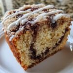 Close-up of a moist slice of Cinnamon Roll Coffee Cake Paleo with cinnamon swirl and white icing drizzle.