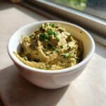 A close-up of Easy Tasty Portuguese Canned Sardine Pate, garnished with fresh parsley, served in a small white bowl.