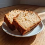 Two golden slices of moist Gluten Free Pound Cake Paleo resting on a small white plate.