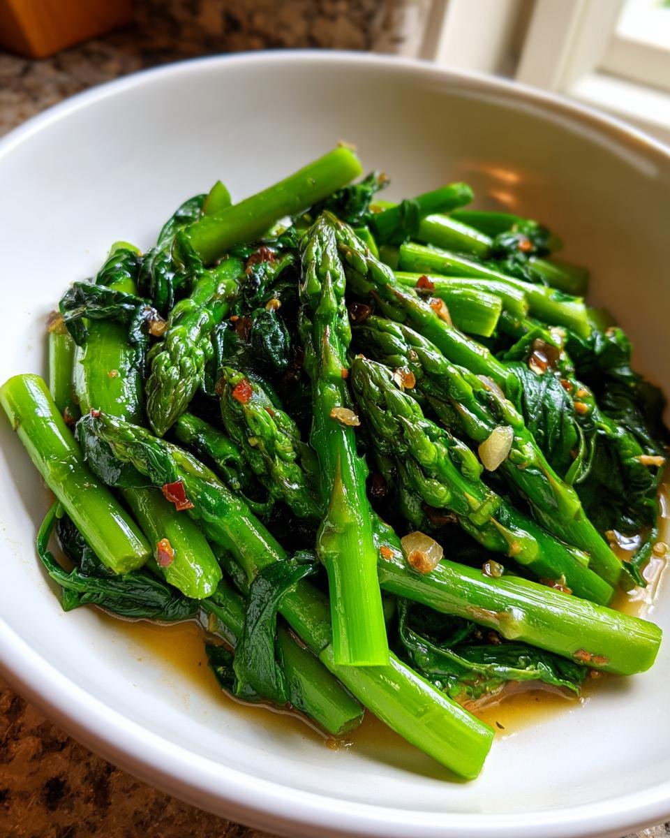 Close-up of bright green asparagus and wilted spinach in a savory sauce, part of the Savory Asparagus Spinach Saute.